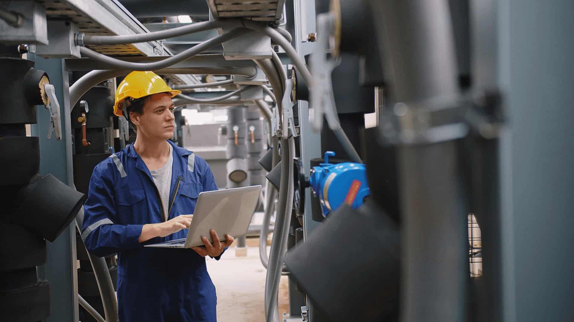 engineer using a laptop to check industrial air-cooling system